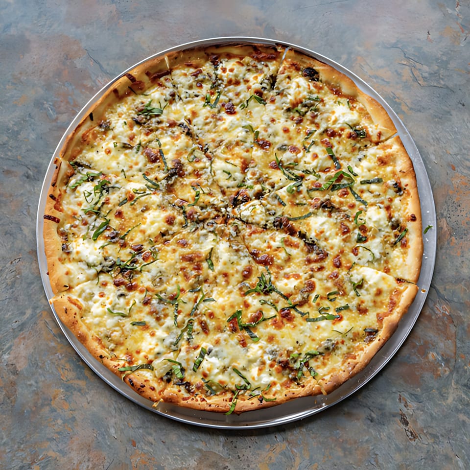 A whole D-Ray's Pizzeria white pizza with melted cheese, green basil, and dark toppings.